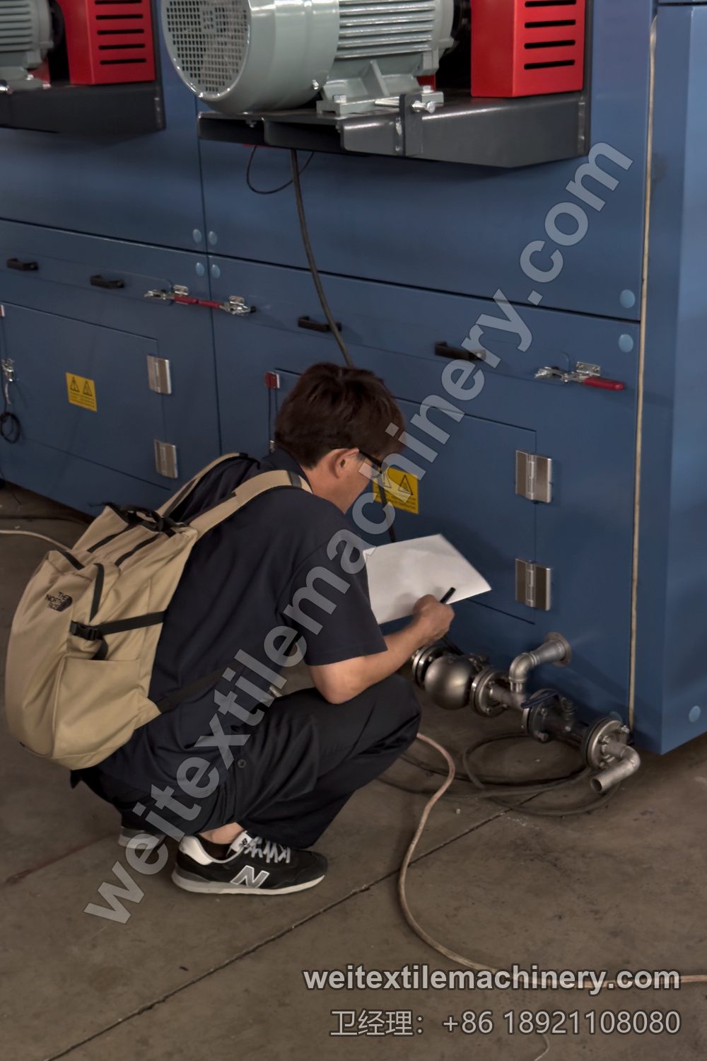 一名御幸毛織工程师蹲在线旁记录