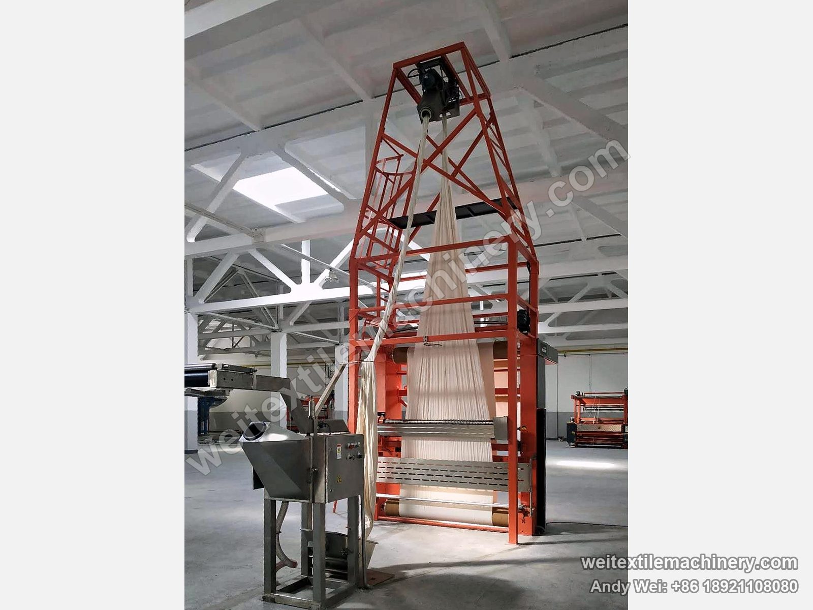 Rope opening machine with a tall orange untwisting tower, cloth rising through it