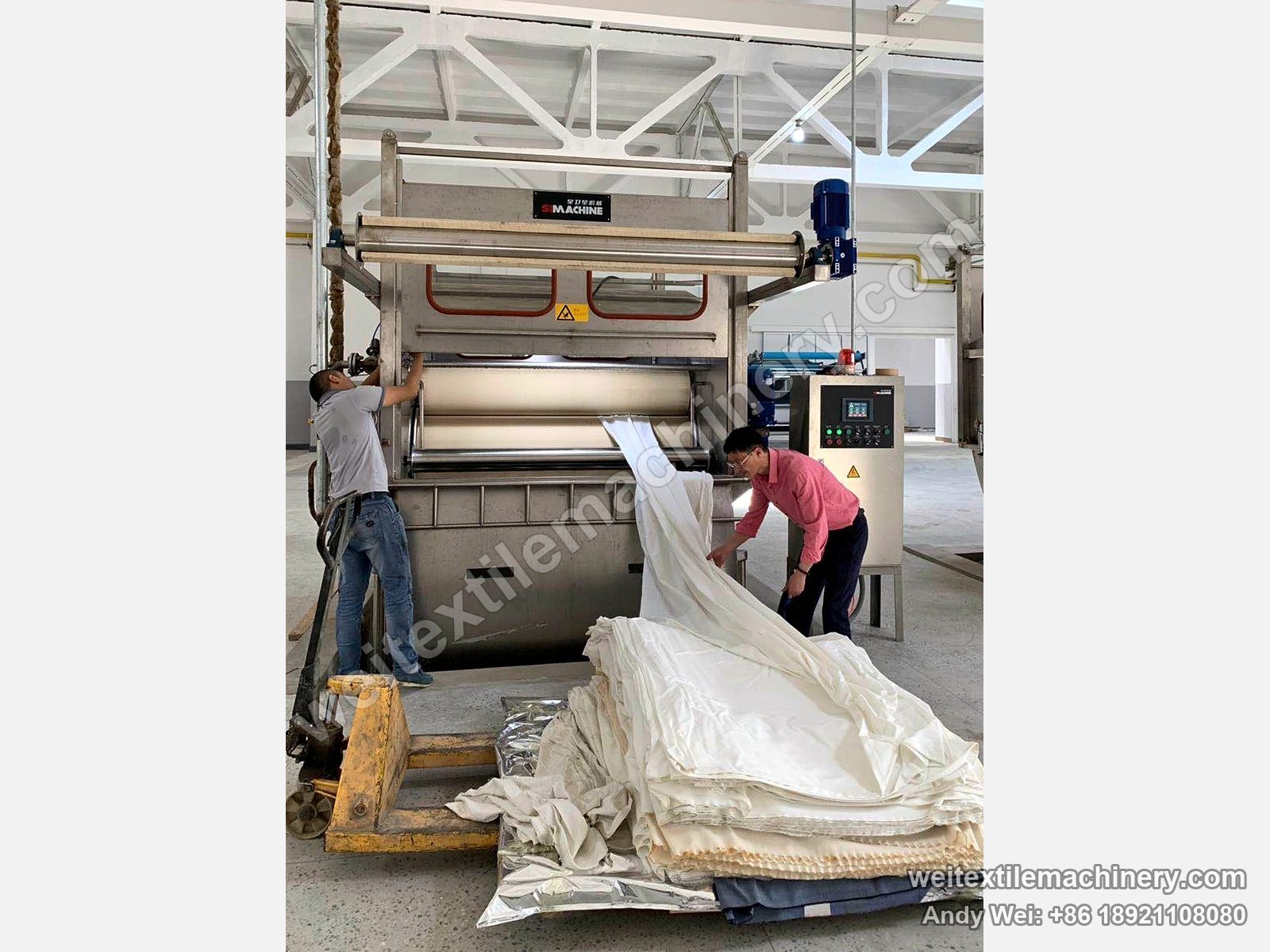 Two technicians loading the first white cloth into a QL rope scouring machine