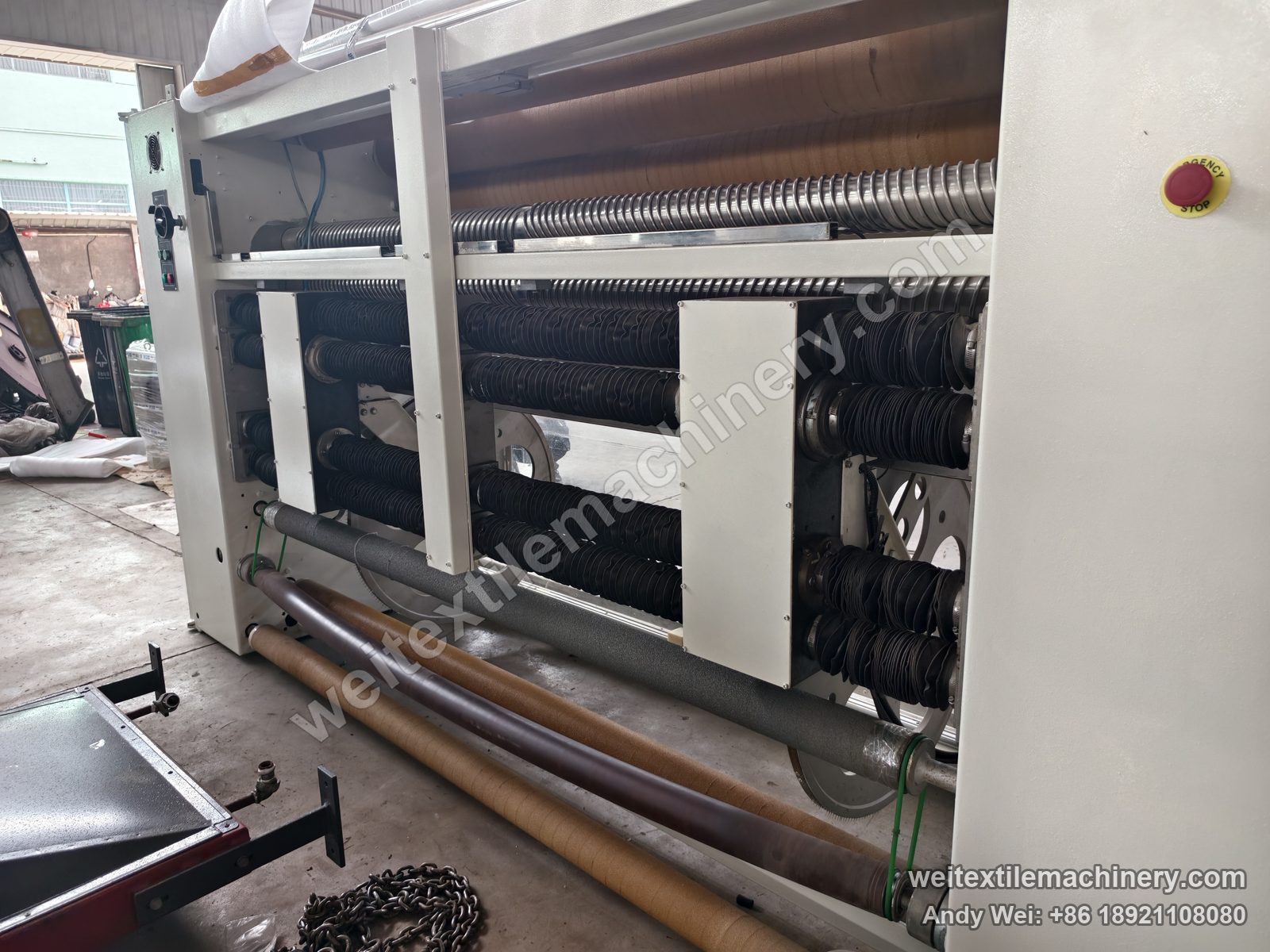 Used Bianco Tramatex SP04 pin-wheel weft straightener, rear view of the correction rollers with bellows and film-wrapped rolls
