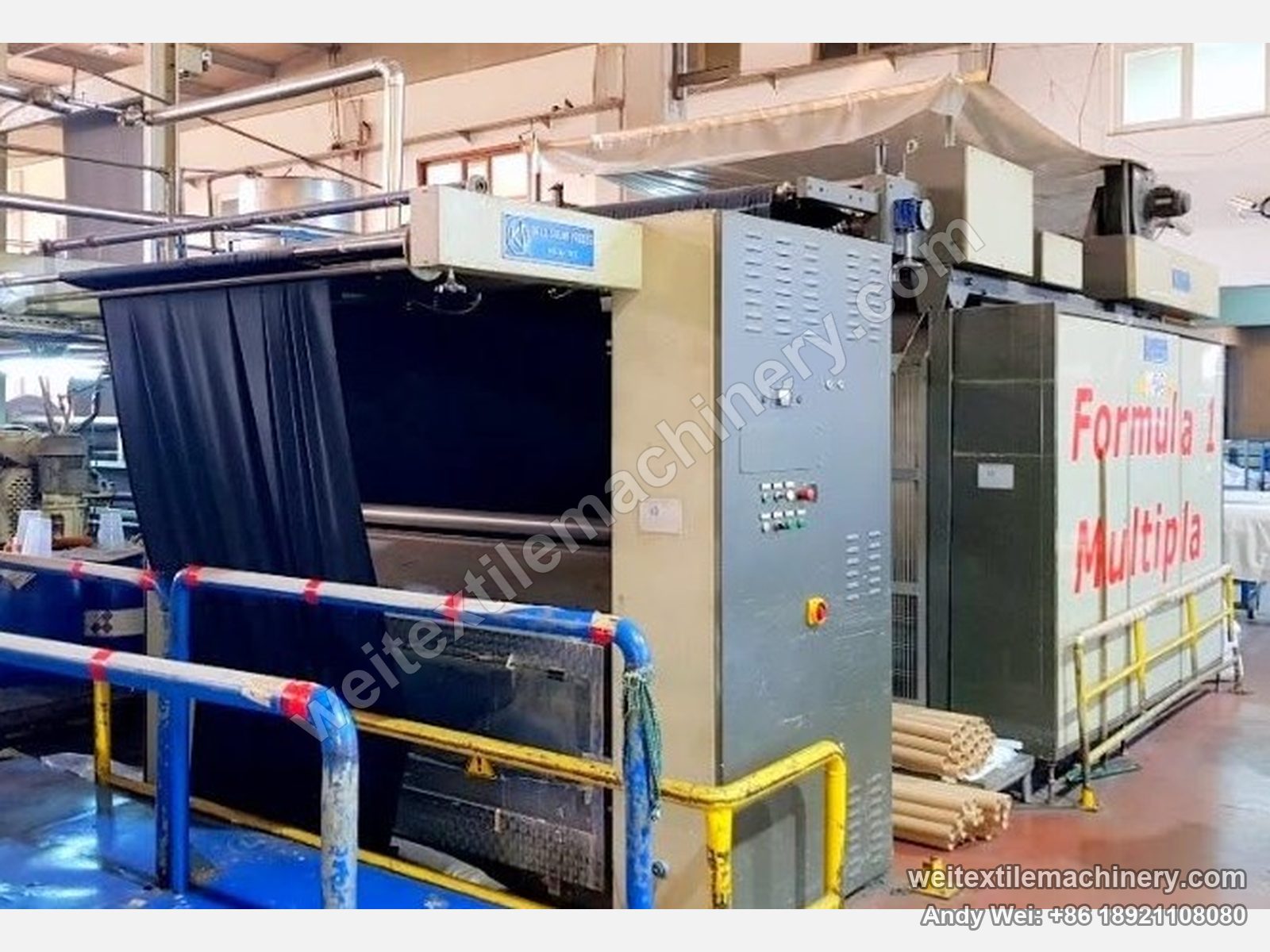 Used KD Formula 1 Formula 1 Multipla moistening-calendering-decatizing machine, view from the other end with blue KD plate, upright cabinet and hanging fabric