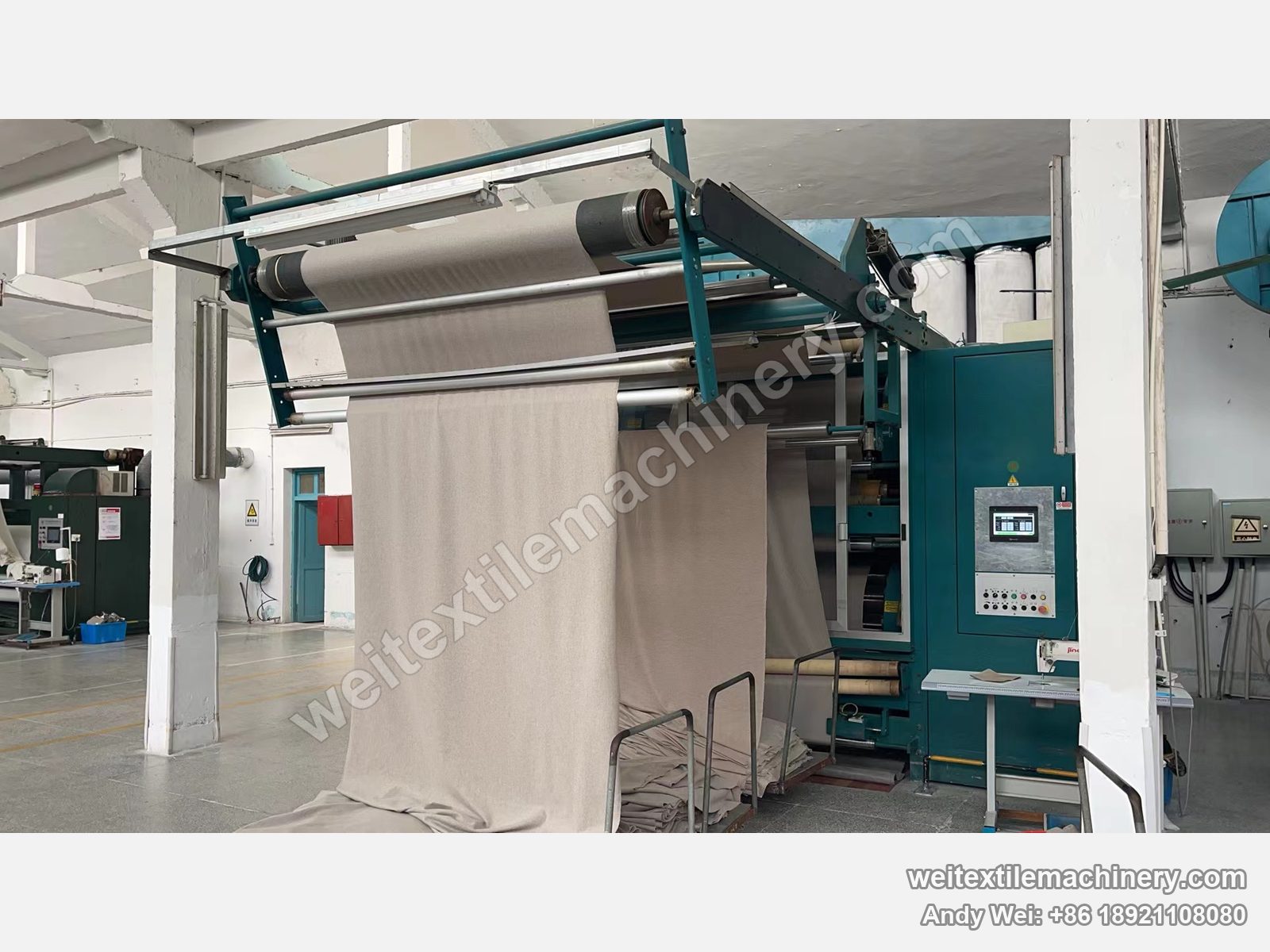 Used Lafer GRI 228 double drum raising machine, front view with blue-green body, touch-screen cabinet and beige fabric on the overhead frame