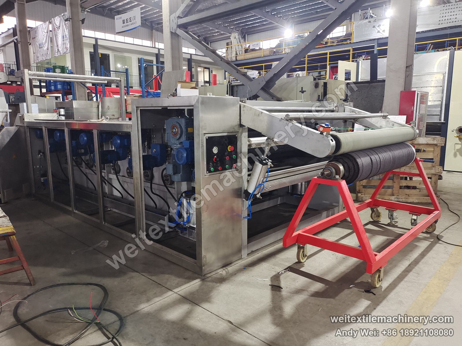 Used TMT STC 4D+4R wet brushing and setting machine, full view with stainless body, row of blue motors, control panel and red fabric roll cart