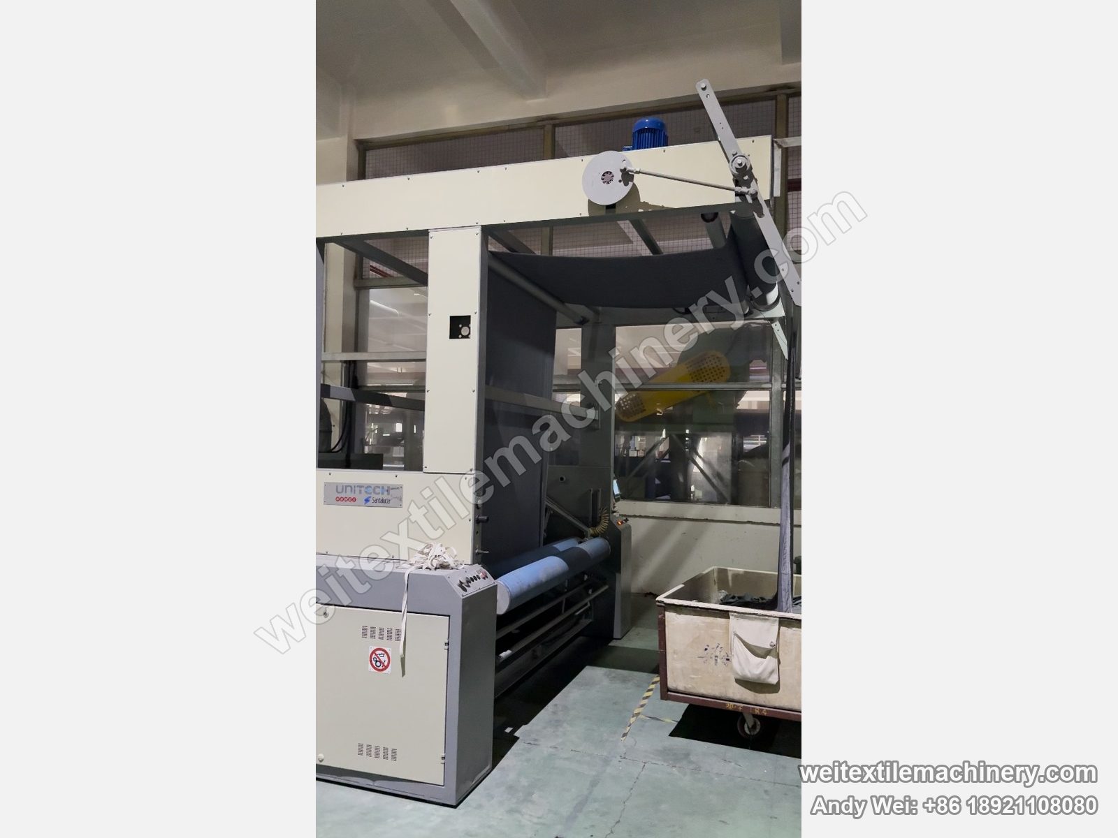 Used Unitech F2 pin-chain steaming-shrinking machine, end unit with UNITECH Santalucia plate, overhead fabric frame with dark fabric and trolley