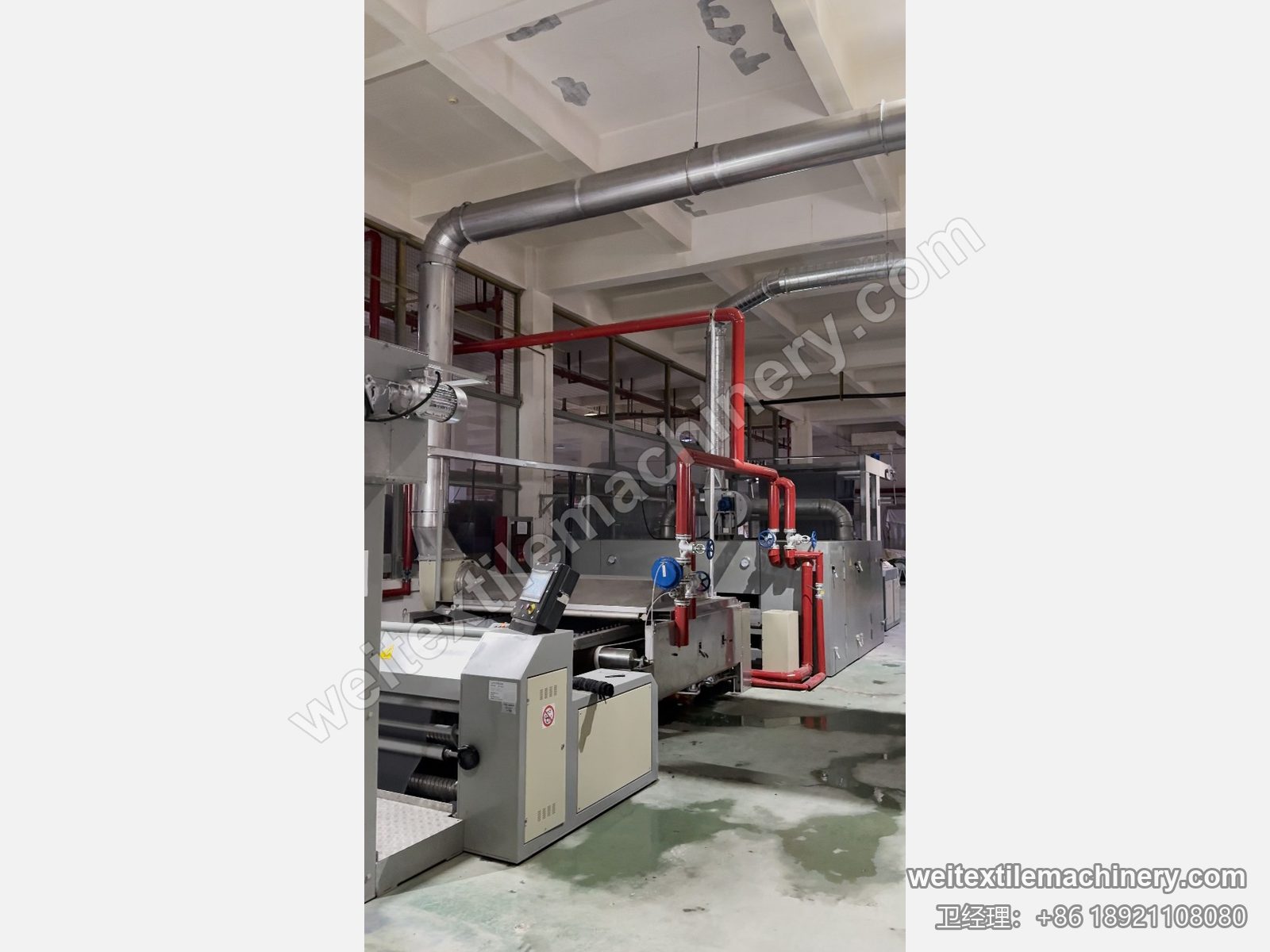 二手 Unitech F2 链条式汽蒸预缩机整线，灰色机身、红色蒸汽管路、顶部排气管与前端操作面板