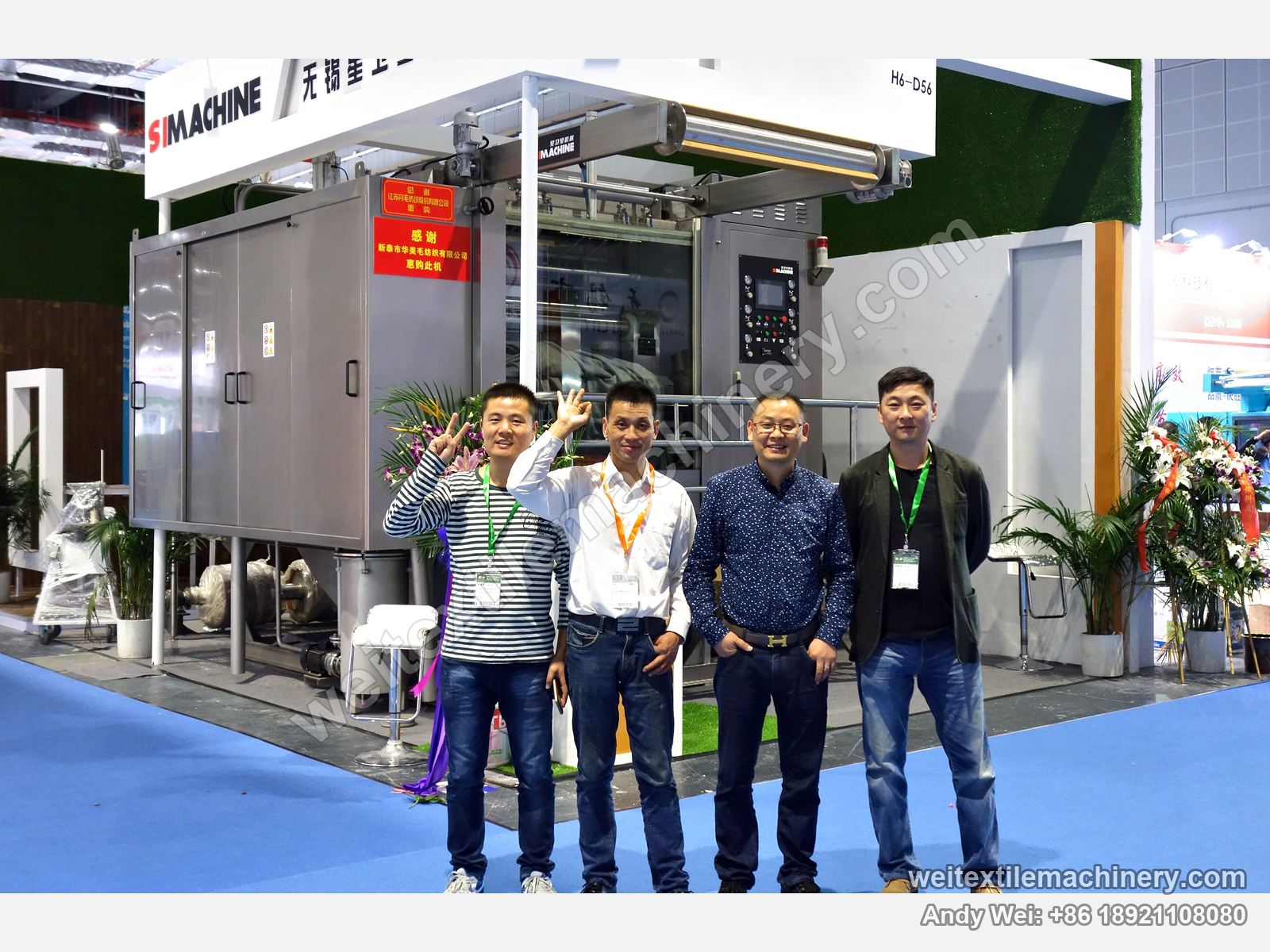 Four people in front of a scouring and milling machine on the 2016 SIMACHINE stand