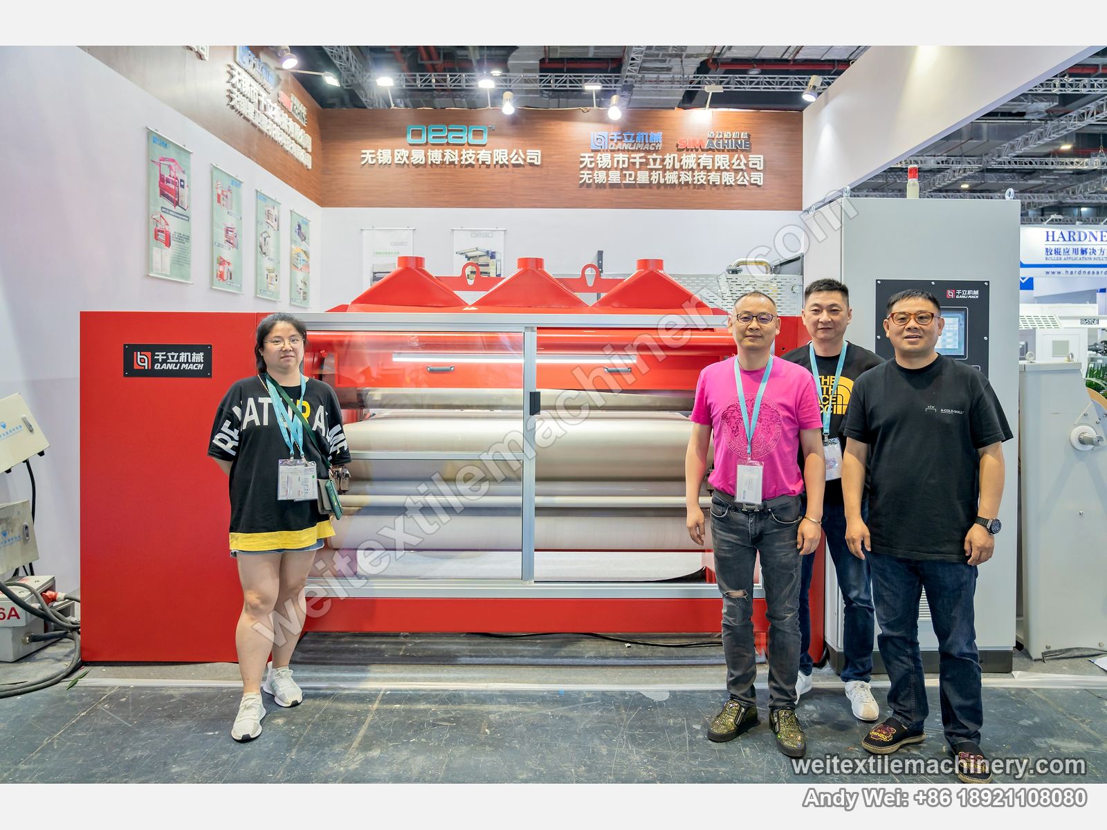Four people in front of a red QL polishing machine on the 2021 stand